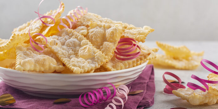 Traditional sweet crisp pastry deep fried and sprinkled with powdered sugar. Carnival food tradition.